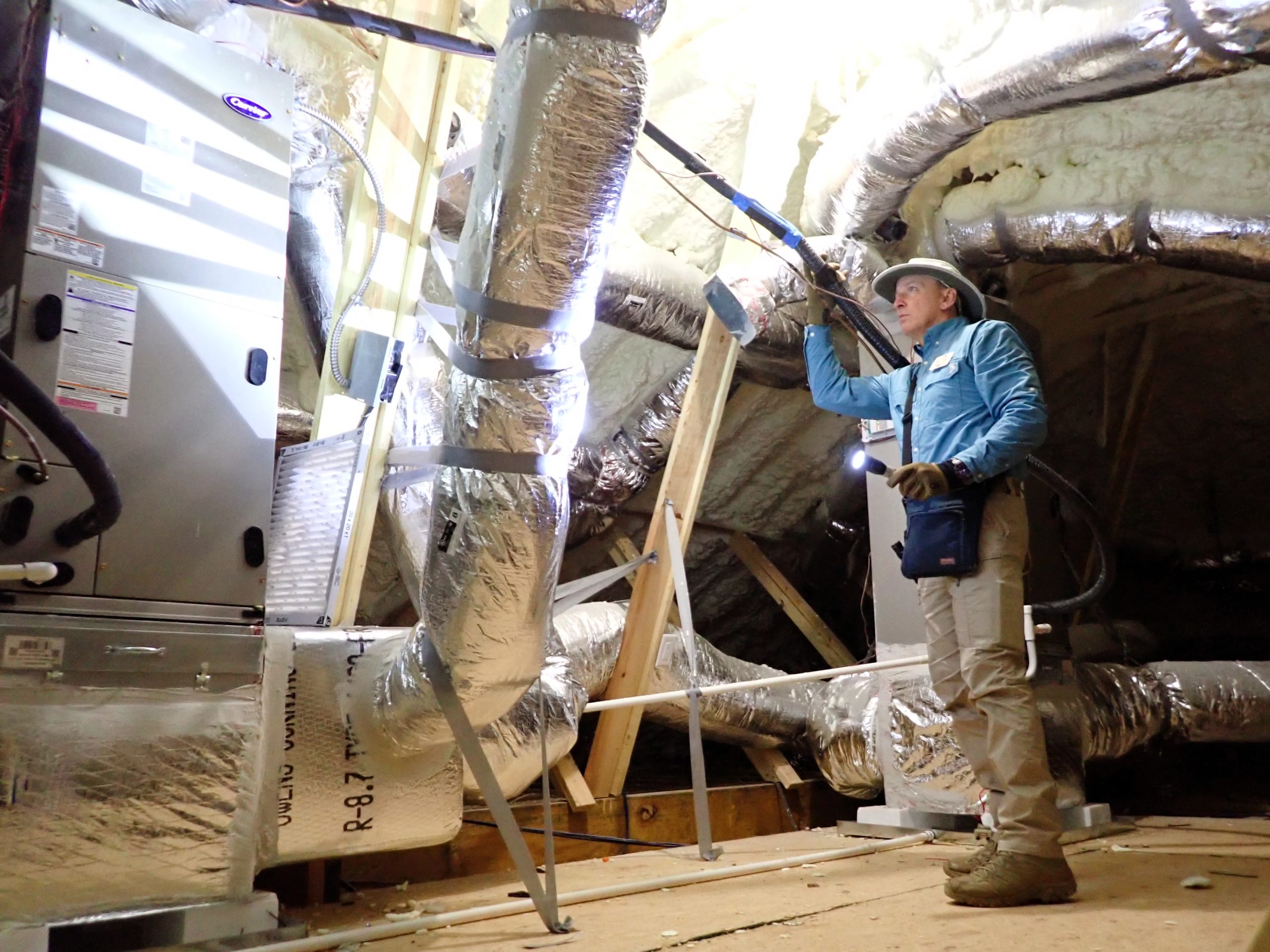 Home inspector performing HVAC and attic duct inspection during pre-listing evaluation