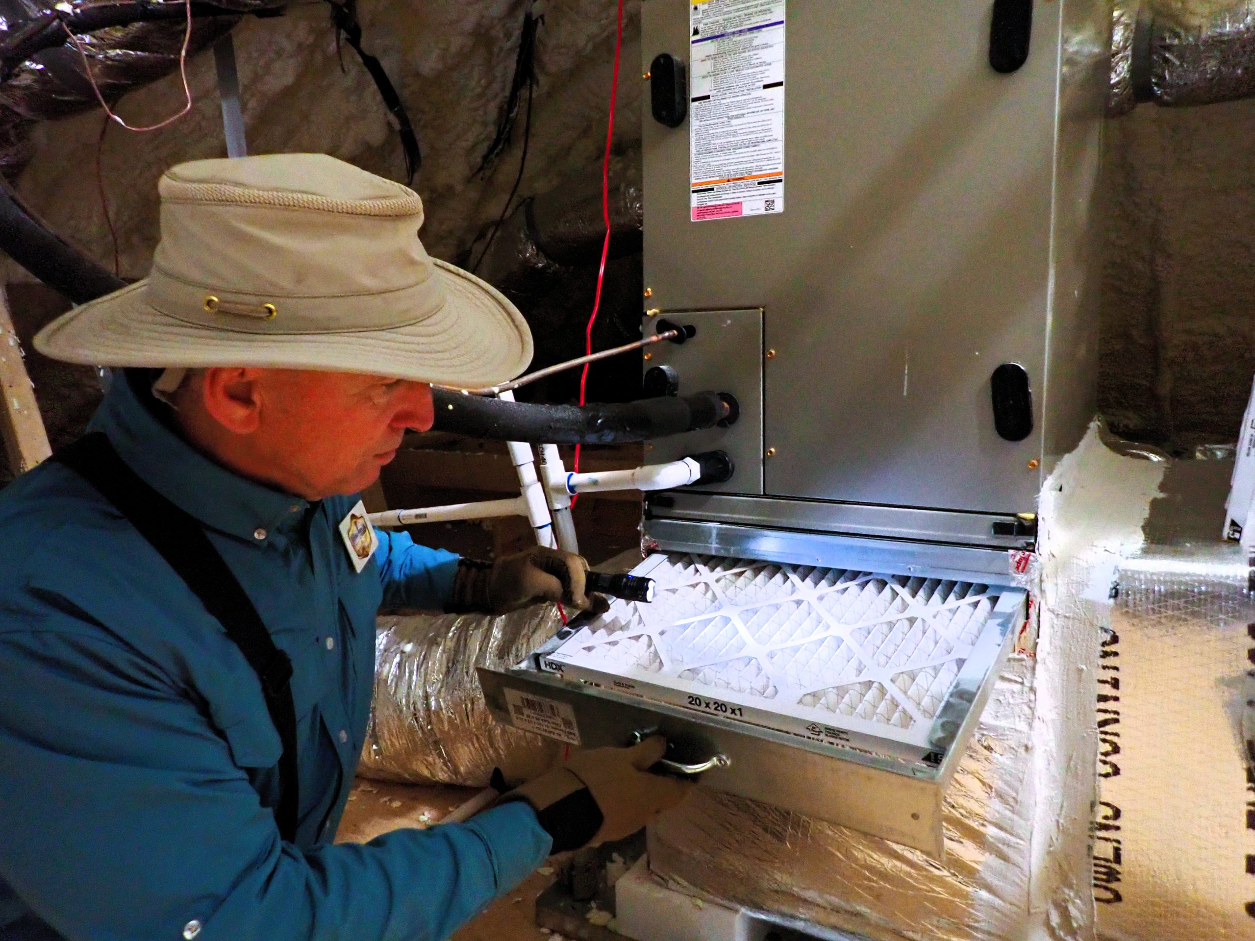 Certified home inspector checking HVAC filter and air handler during a seller-initiated inspection